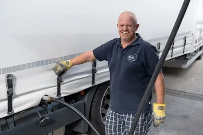 Fahrer an der Plane eines Aufliegers